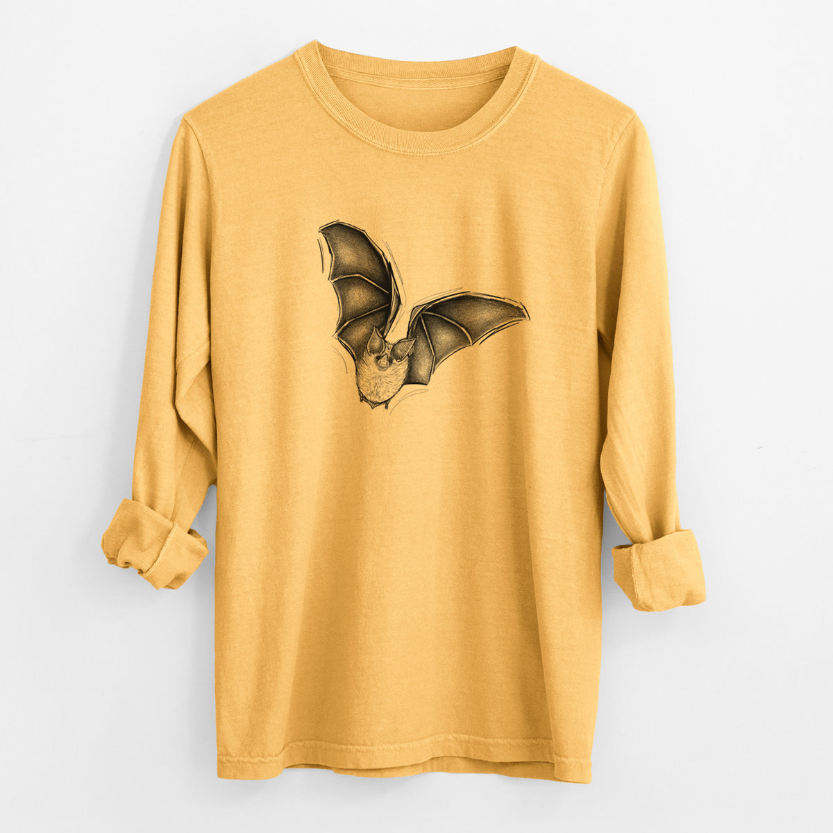 Golden wheat yellow Comfort Colors long sleeve shirt laid flat with the cuffs rolled, printed with a detailed black ink illustration of a California leaf-nosed bat in flight.