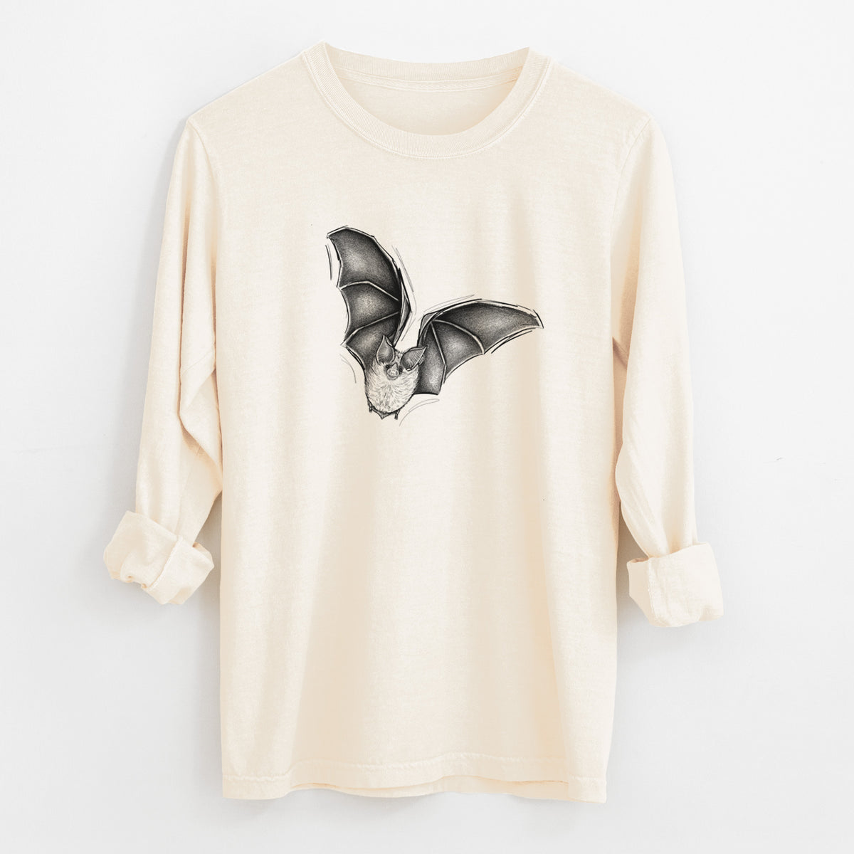 Ivory Comfort Colors long sleeve shirt laid flat with the cuffs rolled, printed with a detailed black ink illustration of a California leaf-nosed bat in flight.