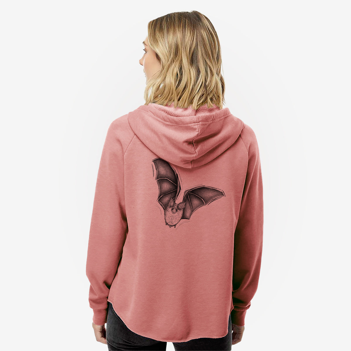 Woman wearing a dusty rose women's Cali Wave zip-up sweatshirt printed with a detailed black ink illustration of a California leaf-nosed bat in flight, seen from behind.