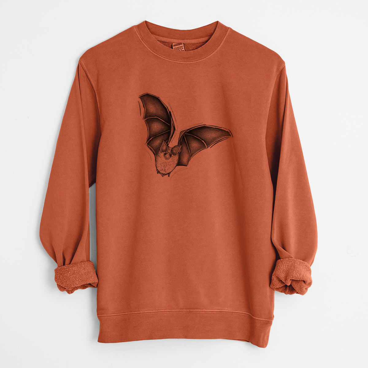 Amber orange pigment dyed crewneck sweatshirt laid flat with the sleeves rolled, printed with a detailed black ink illustration of a California leaf-nosed bat in flight.