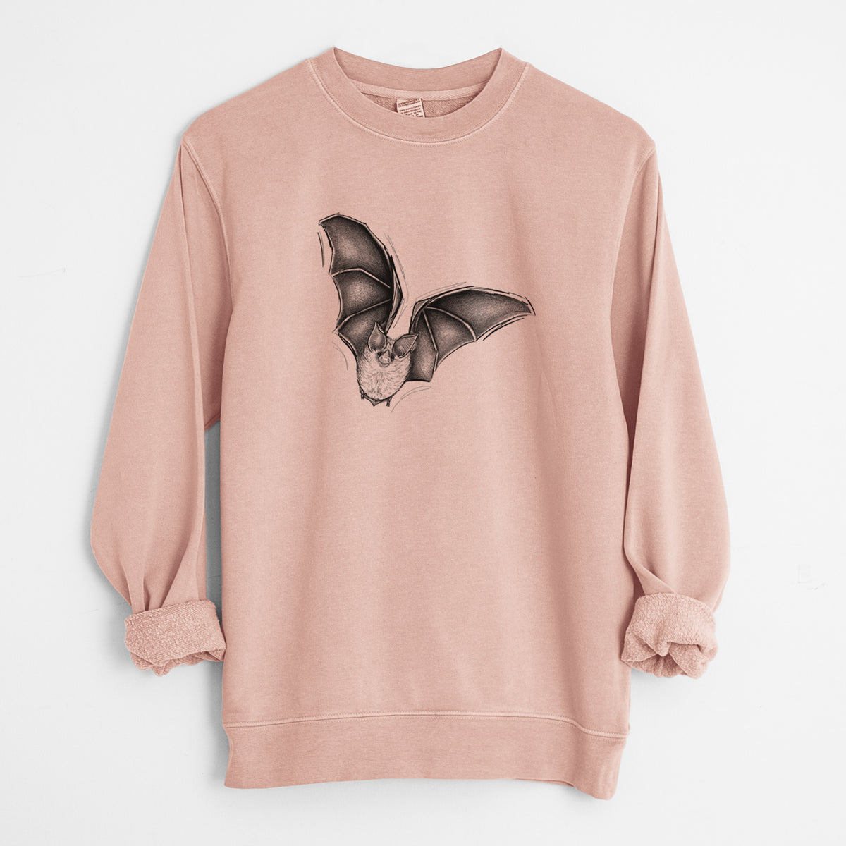 Dusty pink pigment dyed crewneck sweatshirt laid flat with the sleeves rolled, printed with a detailed black ink illustration of a California leaf-nosed bat in flight.
