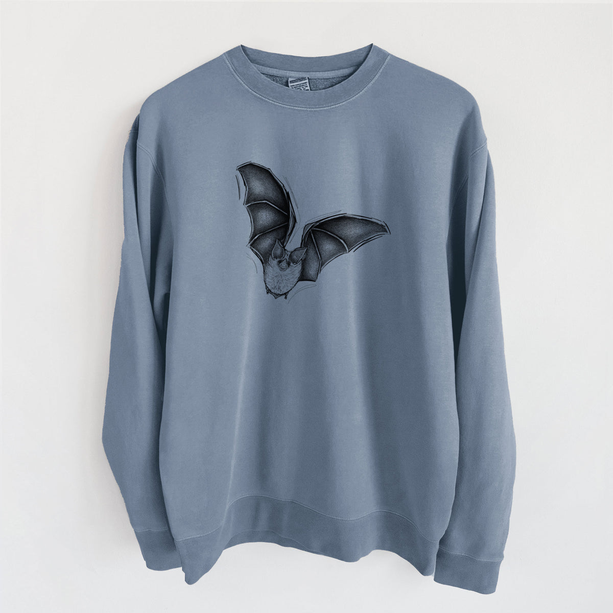 Slate blue pigment dyed crewneck sweatshirt laid flat, printed with a detailed black ink illustration of a California leaf-nosed bat in flight.