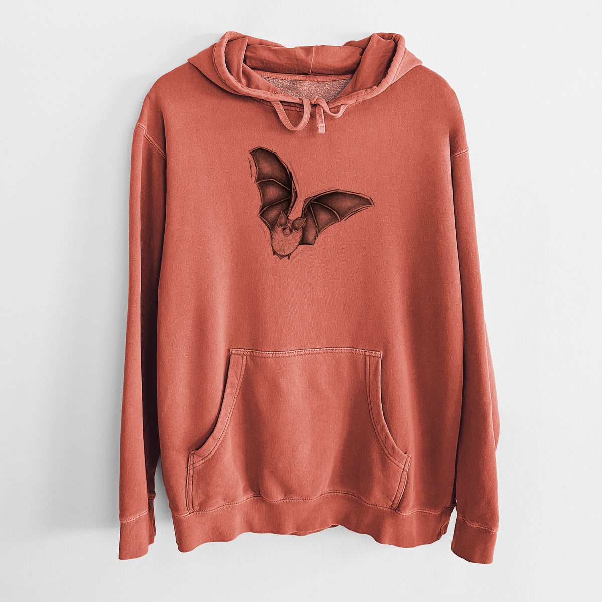 Amber orange pigment dyed hoodie laid flat, printed with a detailed black ink illustration of a California leaf-nosed bat in flight.
