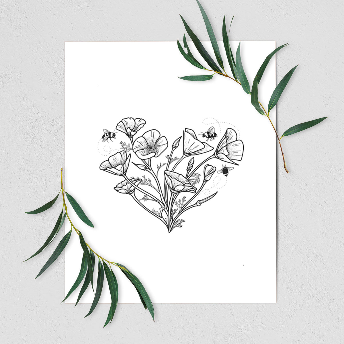 Art print of a black ink line drawing of California poppies arranged in a heart shape, with small bees, shown with eucalyptus leaves.