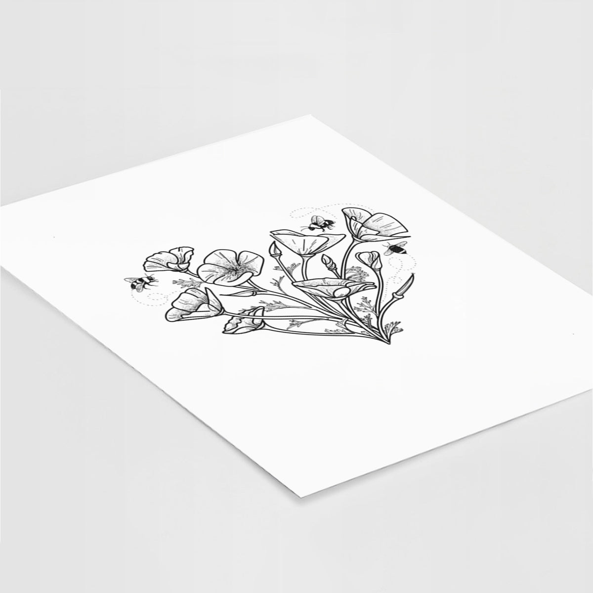 Art print of a black ink line drawing of California poppies arranged in a heart shape, with small bees, lying at an angle on a white surface.