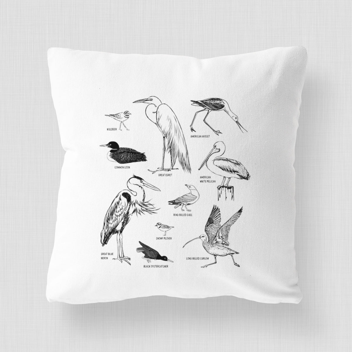 White pillow cover printed with a chart of black ink California shorebirds, including herons, egrets, avocets and sandpipers.