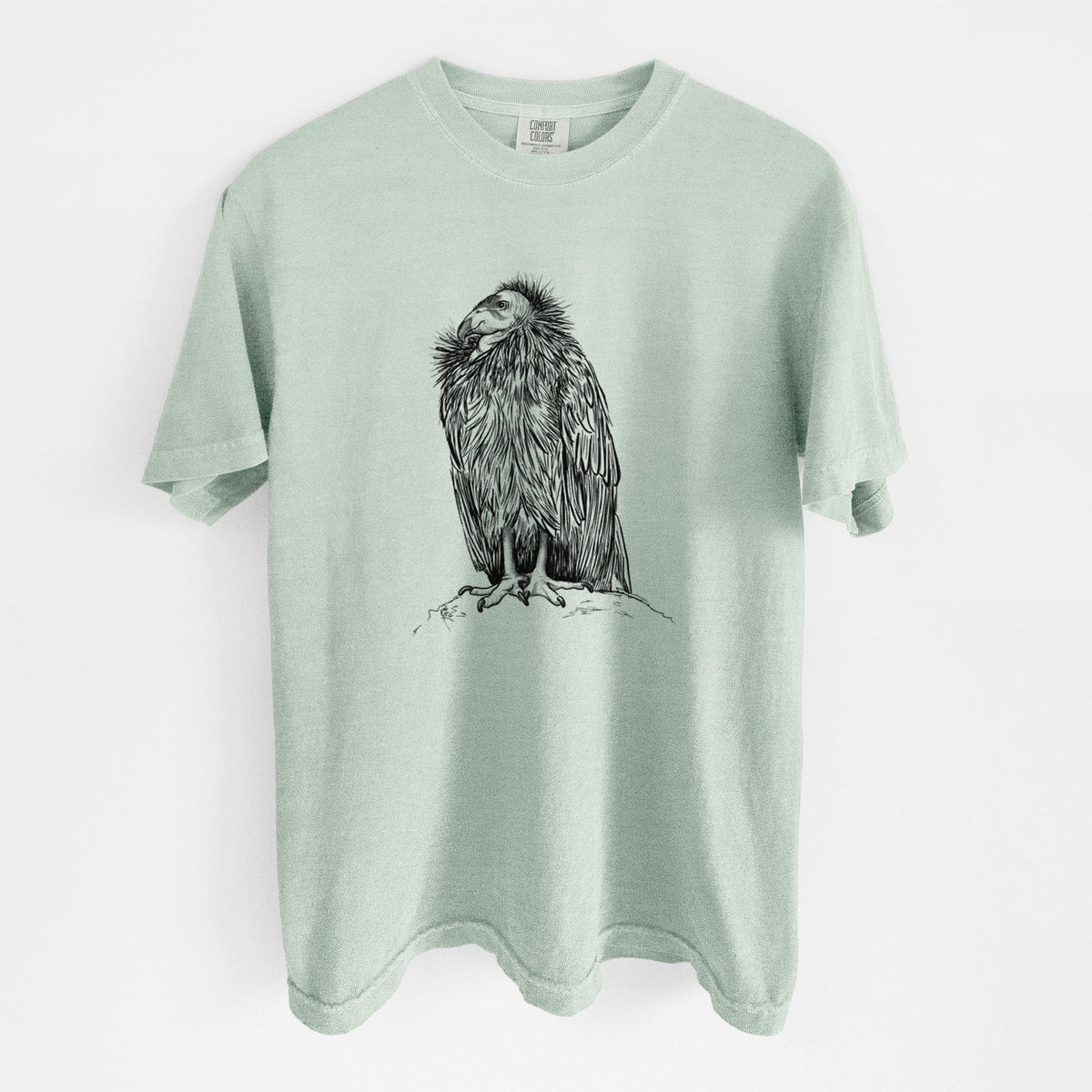 Bay green Comfort Colors t-shirt laid flat, printed with a detailed black ink illustration of a California condor perched with folded wings.