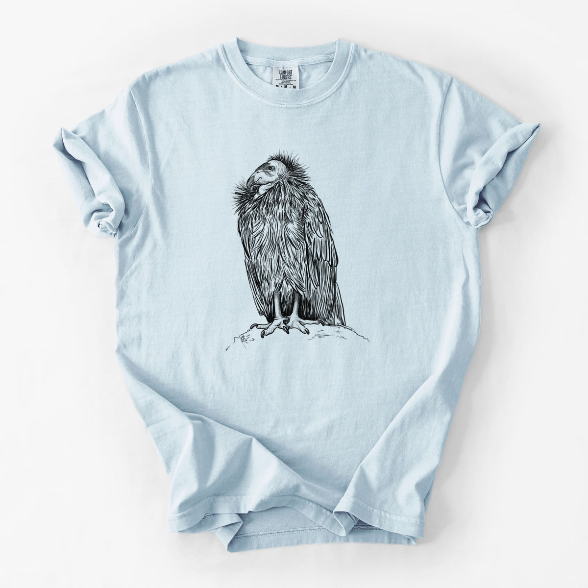 Chambray blue Comfort Colors t-shirt laid flat, printed with a detailed black ink illustration of a California condor perched with folded wings.