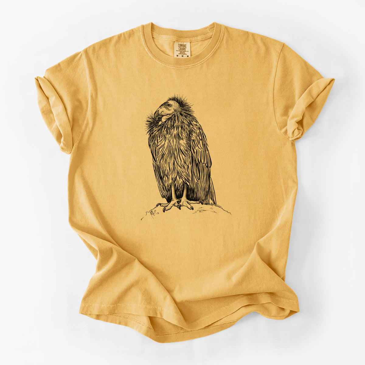 Golden wheat yellow Comfort Colors t-shirt laid flat, printed with a detailed black ink illustration of a California condor perched with folded wings.