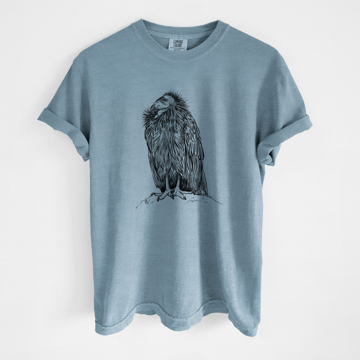 Steel blue Comfort Colors t-shirt laid flat, printed with a detailed black ink illustration of a California condor perched with folded wings.