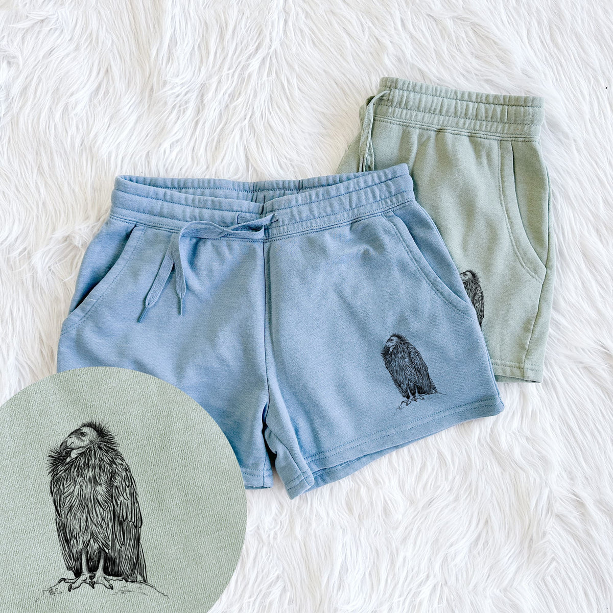 Two pairs of Cali Wave shorts in different colors printed with a detailed black ink illustration of a California condor perched with folded wings, with a close-up of the print.