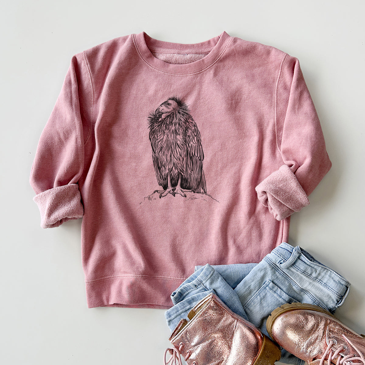 Youth crewneck sweatshirt printed with a detailed black ink illustration of a California condor perched with folded wings, styled flat with jeans and boots.