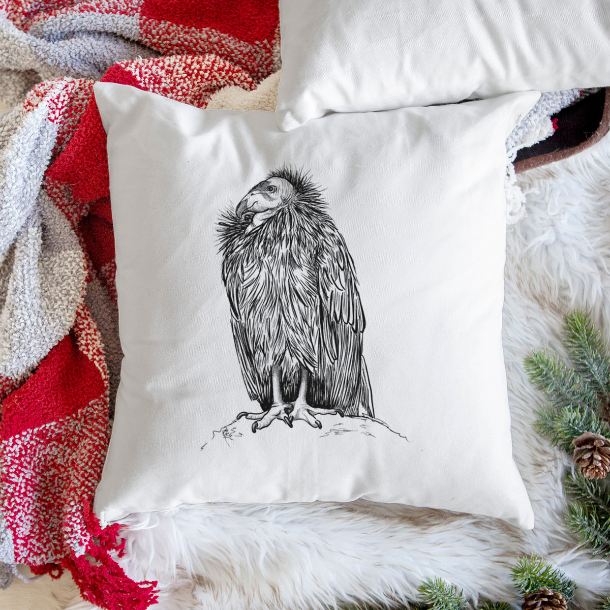 White pillow cover printed with a detailed black ink illustration of a California condor perched with folded wings, on a woven chair.