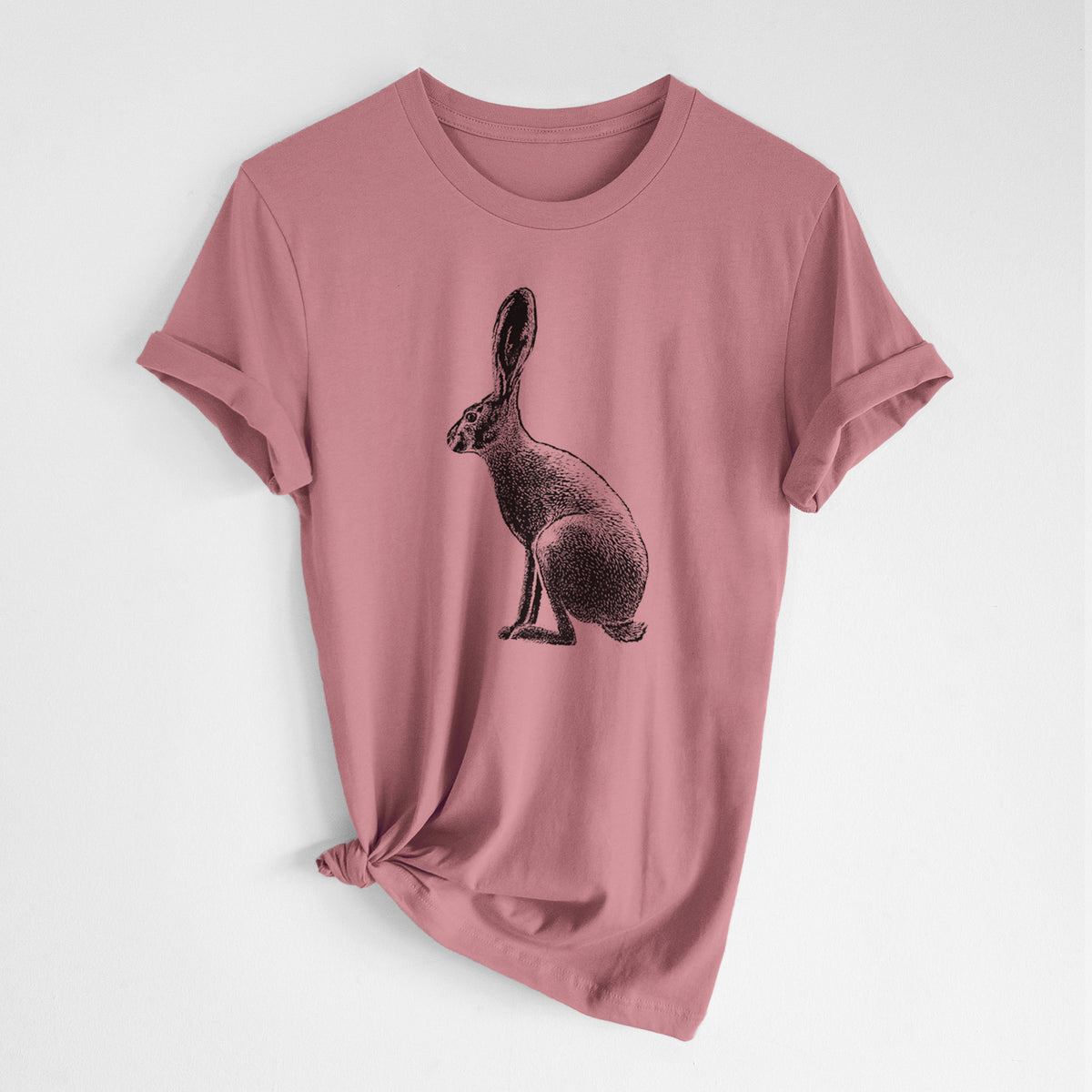 Mauve pink lightweight cotton t-shirt laid flat with the sleeves rolled, printed with a detailed black ink illustration of a black-tailed jackrabbit sitting in profile with tall ears.