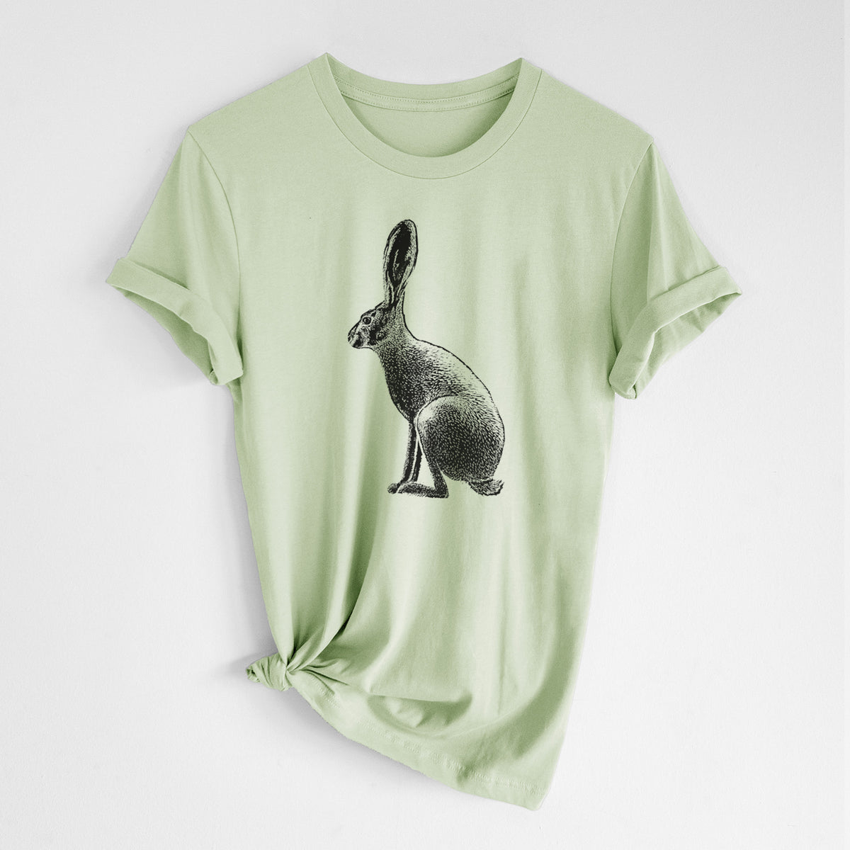 Spring green lightweight cotton t-shirt laid flat with the sleeves rolled, printed with a detailed black ink illustration of a black-tailed jackrabbit sitting in profile with tall ears.