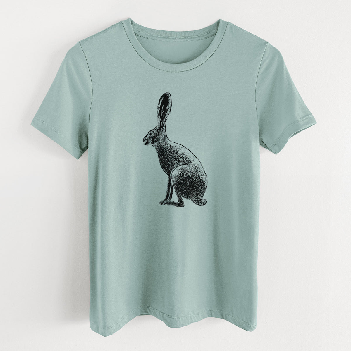 Dusty blue women's relaxed fit cotton t-shirt laid flat, printed with a detailed black ink illustration of a black-tailed jackrabbit sitting in profile with tall ears.