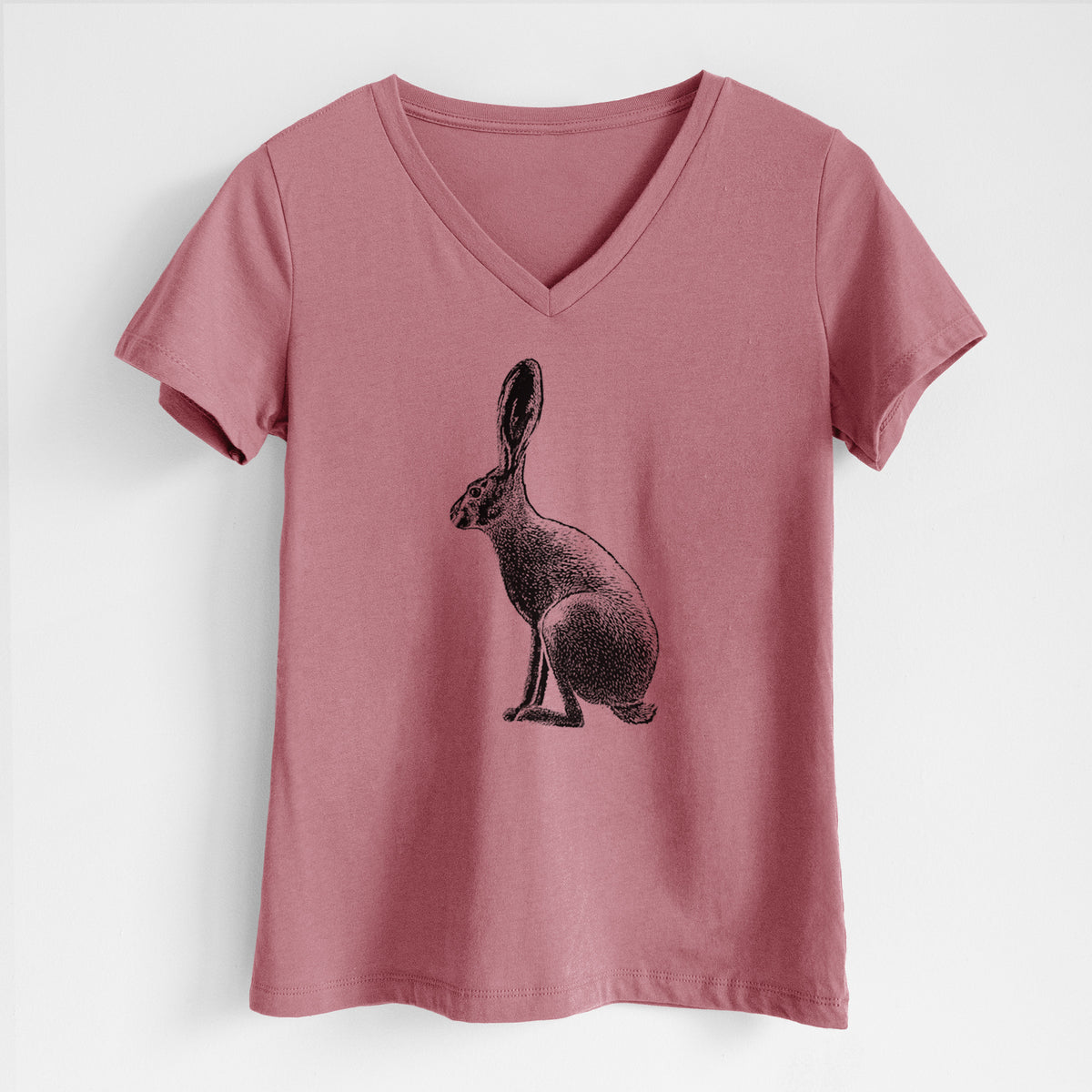 Mauve pink women's relaxed fit cotton V-neck t-shirt laid flat, printed with a detailed black ink illustration of a black-tailed jackrabbit sitting in profile with tall ears.