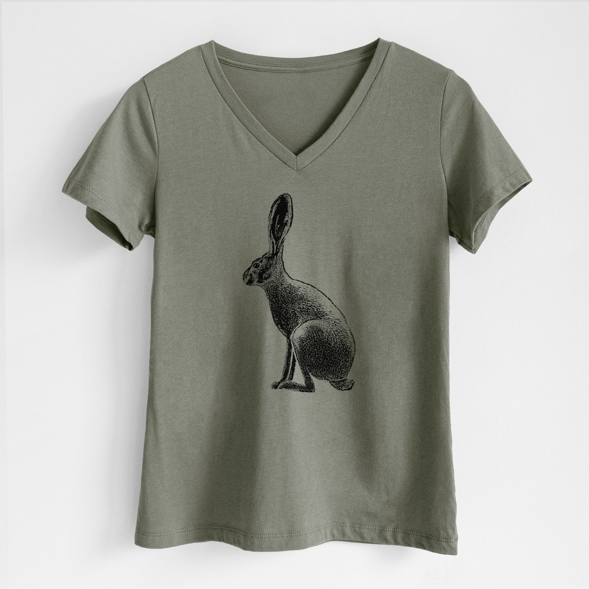 Military green women's relaxed fit cotton V-neck t-shirt laid flat, printed with a detailed black ink illustration of a black-tailed jackrabbit sitting in profile with tall ears.