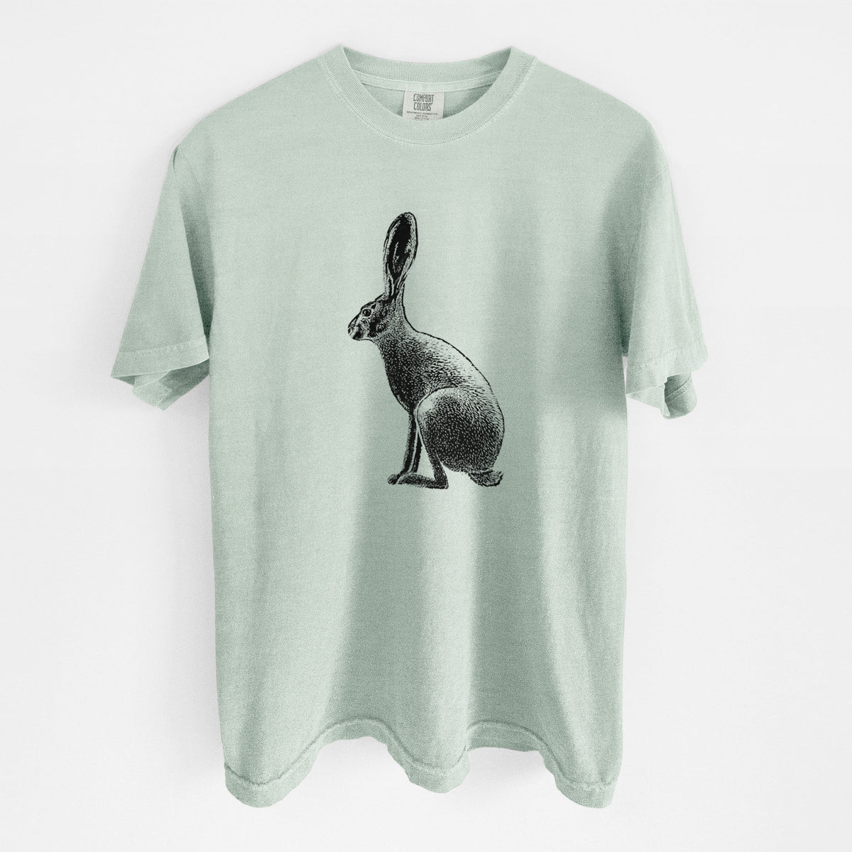 Bay green Comfort Colors t-shirt laid flat, printed with a detailed black ink illustration of a black-tailed jackrabbit sitting in profile with tall ears.