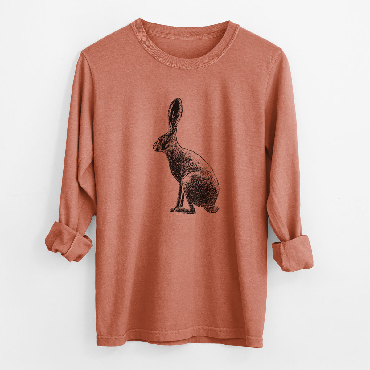 Yam burnt orange Comfort Colors long sleeve shirt laid flat with the cuffs rolled, printed with a detailed black ink illustration of a black-tailed jackrabbit sitting in profile with tall ears.
