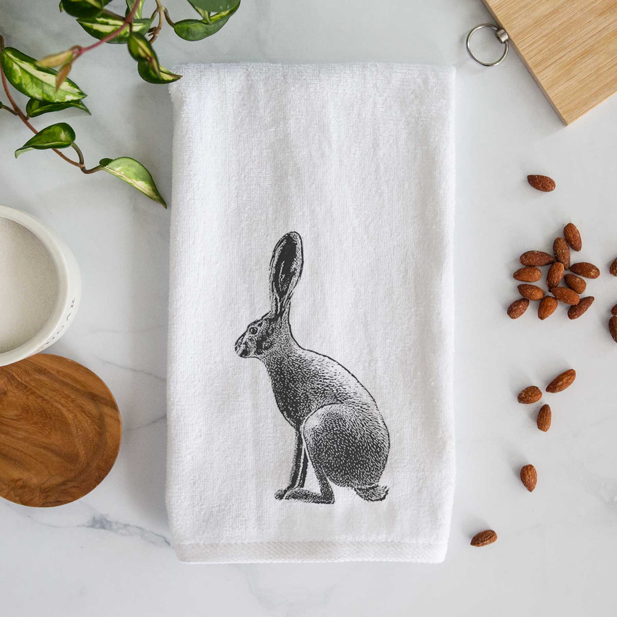 White hand towel printed with a detailed black ink illustration of a black-tailed jackrabbit sitting in profile with tall ears.