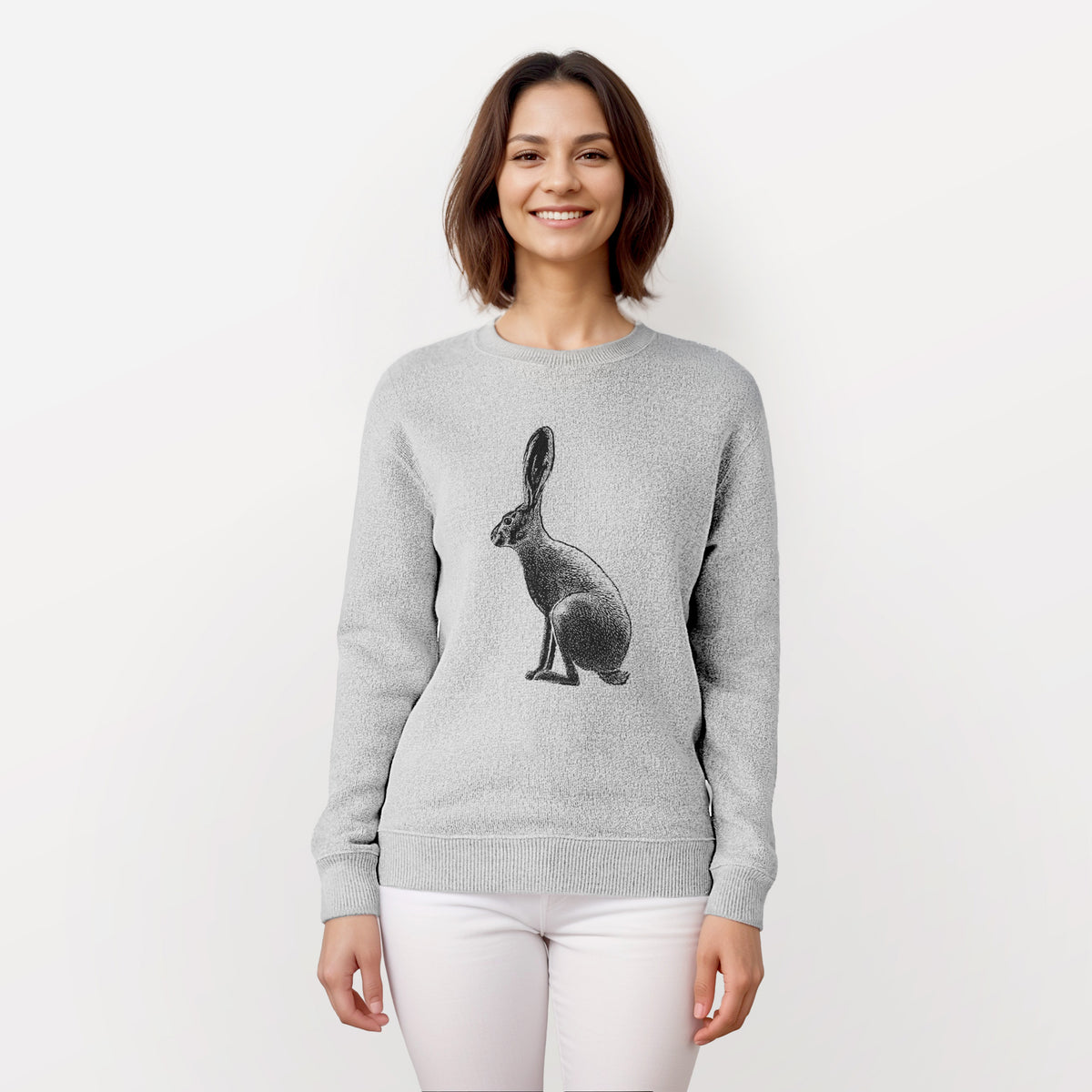 Woman wearing a knit sweatshirt printed with a detailed black ink illustration of a black-tailed jackrabbit sitting in profile with tall ears.