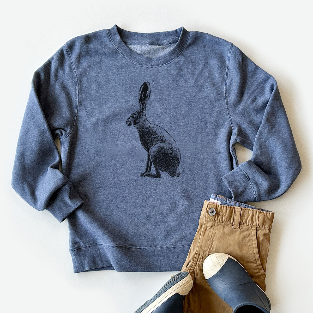 Youth crewneck sweatshirt printed with a detailed black ink illustration of a black-tailed jackrabbit sitting in profile with tall ears, styled flat with khaki pants and shoes.