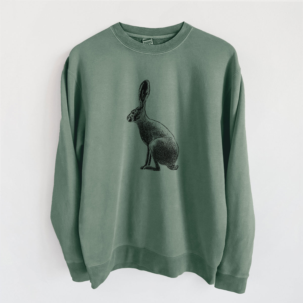 Alpine green pigment dyed crewneck sweatshirt laid flat, printed with a detailed black ink illustration of a black-tailed jackrabbit sitting in profile with tall ears.