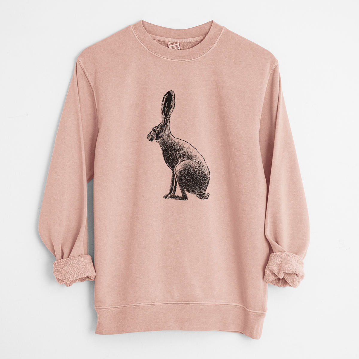 Dusty pink pigment dyed crewneck sweatshirt laid flat with the sleeves rolled, printed with a detailed black ink illustration of a black-tailed jackrabbit sitting in profile with tall ears.