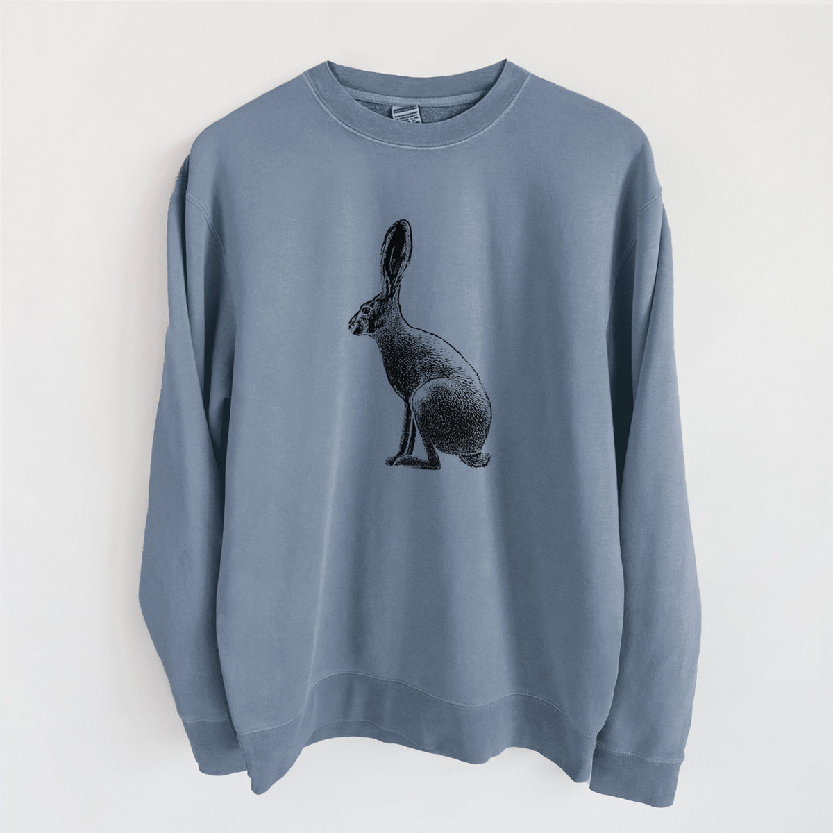 Slate blue pigment dyed crewneck sweatshirt laid flat, printed with a detailed black ink illustration of a black-tailed jackrabbit sitting in profile with tall ears.