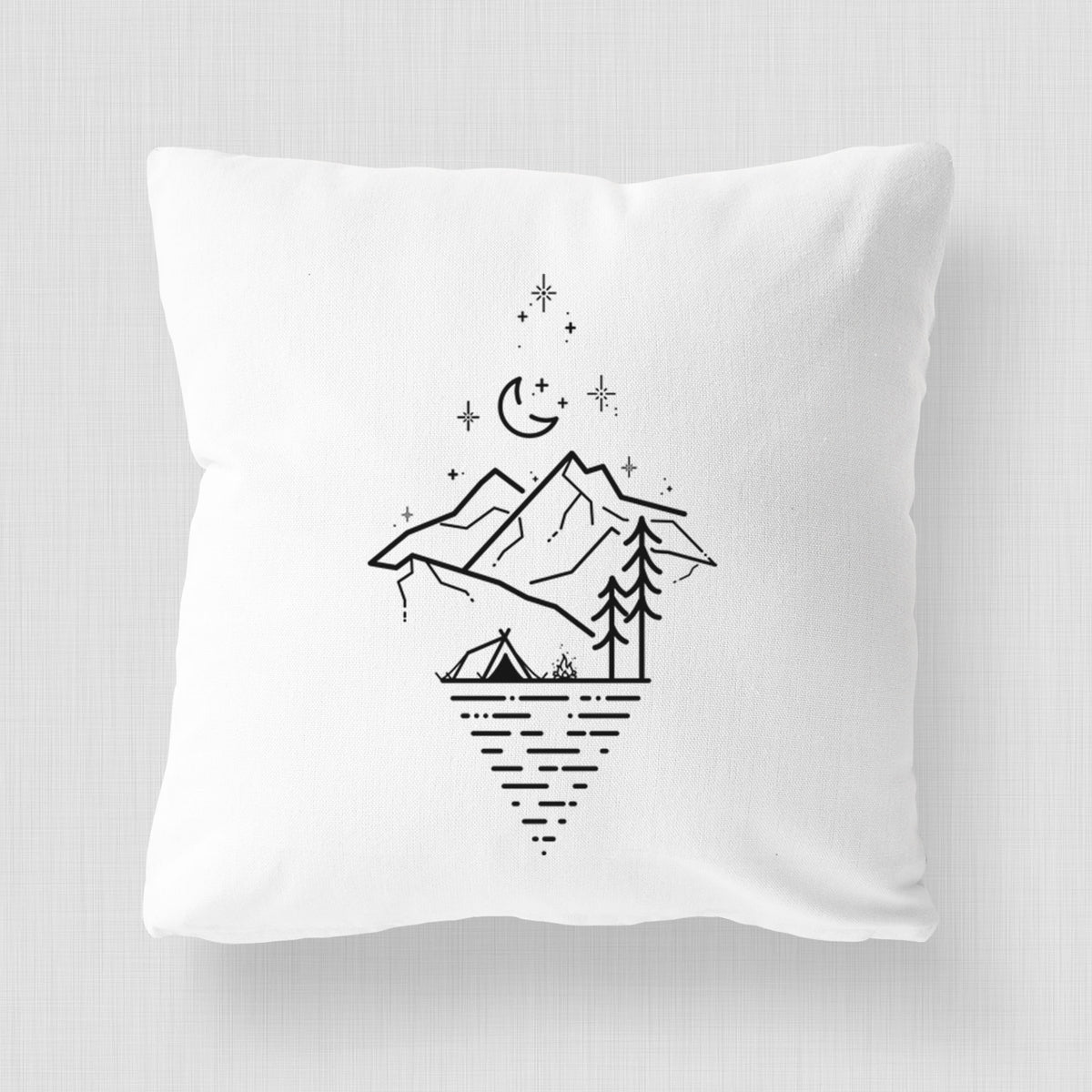 White pillow cover printed with black line art of mountains, pine trees, a crescent moon and stars above a lake inside a diamond outline.