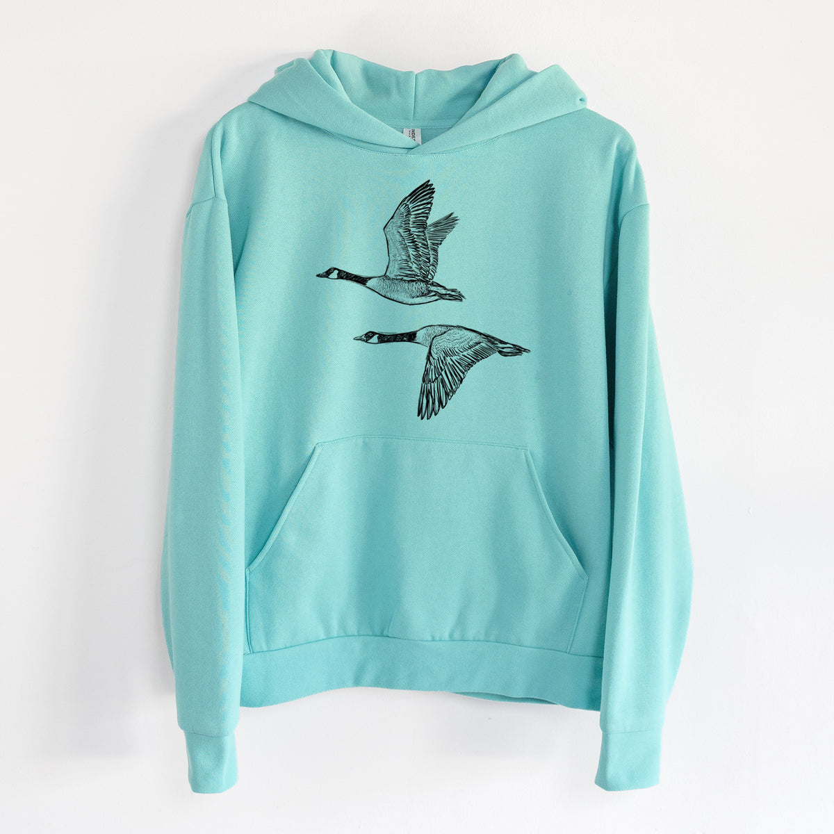 Canada Geese in Flight - Branta canadensis - Statement Midweight Hoodie in Seafoam, hanging on a white wall, with a front kangaroo pocket and no drawcords.