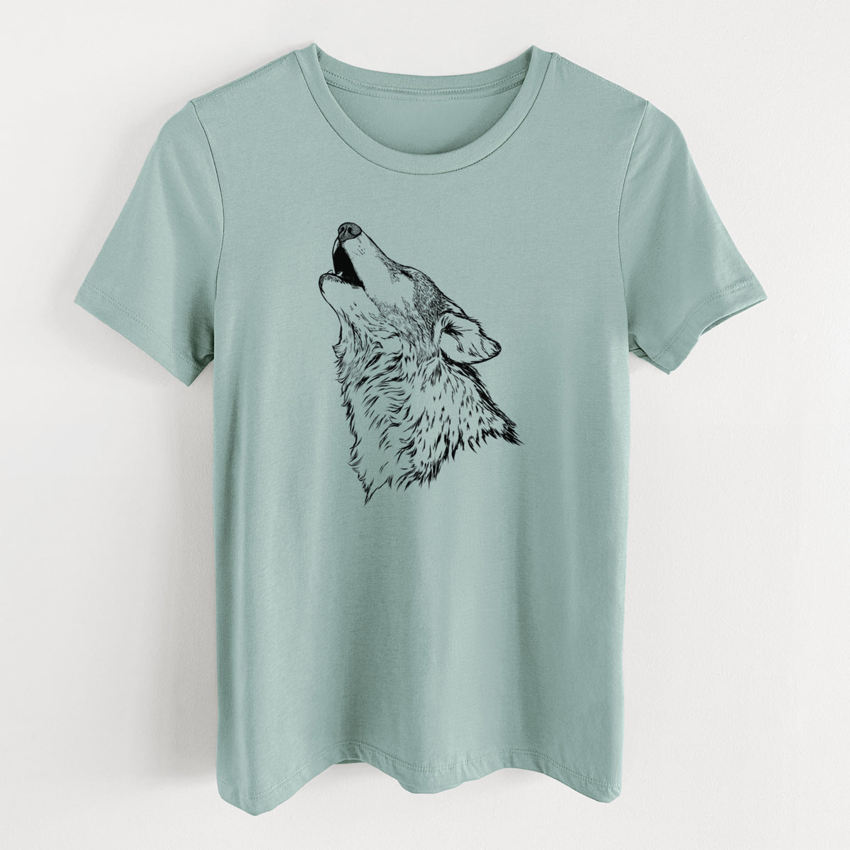 Dusty blue women's relaxed fit cotton t-shirt laid flat, printed with a detailed black ink illustration of a grey wolf's head and shoulders, howling upward.