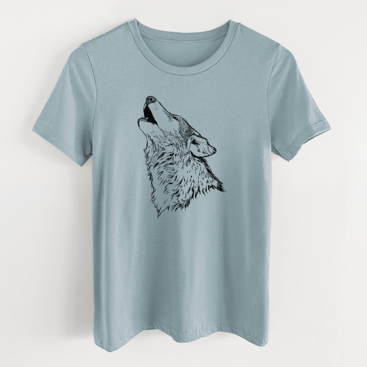 Vintage denim women's relaxed fit cotton t-shirt laid flat, printed with a detailed black ink illustration of a grey wolf's head and shoulders, howling upward.
