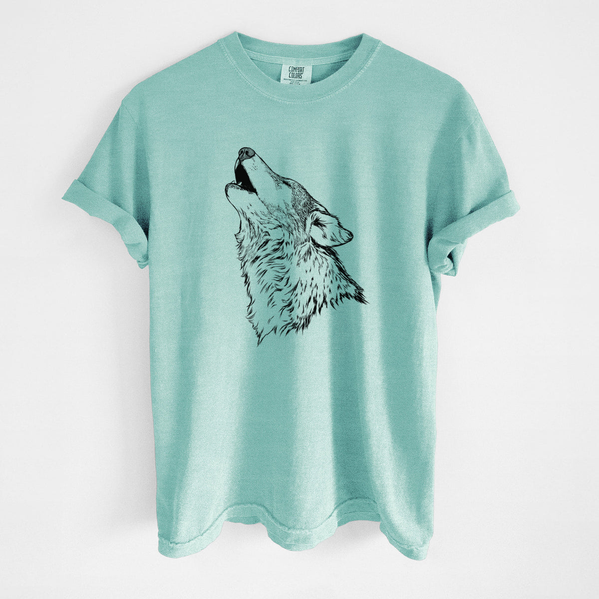 Chalky mint Comfort Colors t-shirt laid flat, printed with a detailed black ink illustration of a grey wolf's head and shoulders, howling upward.