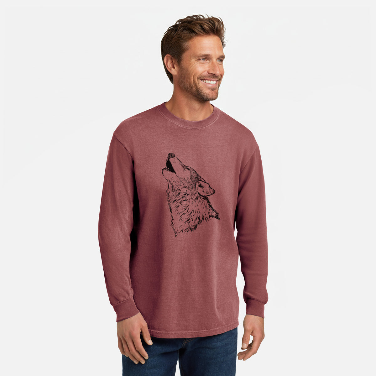 Brick red Comfort Colors long sleeve shirt printed with a detailed black ink illustration of a grey wolf's head and shoulders, howling upward, shown in a lifestyle photo.