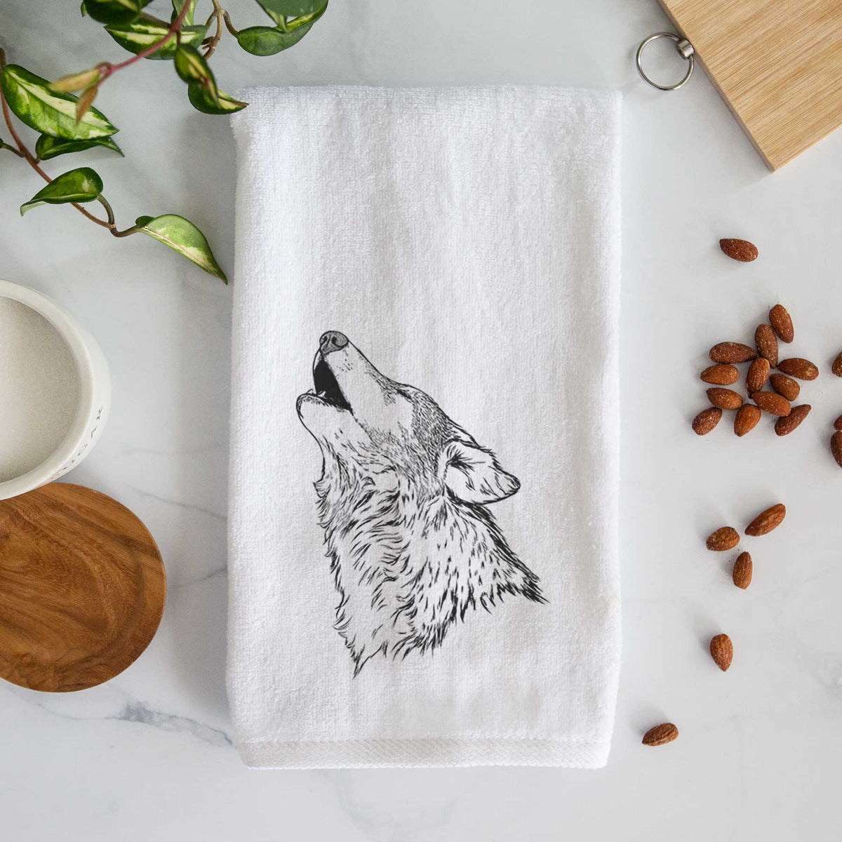 White hand towel printed with a detailed black ink illustration of a grey wolf's head and shoulders, howling upward.