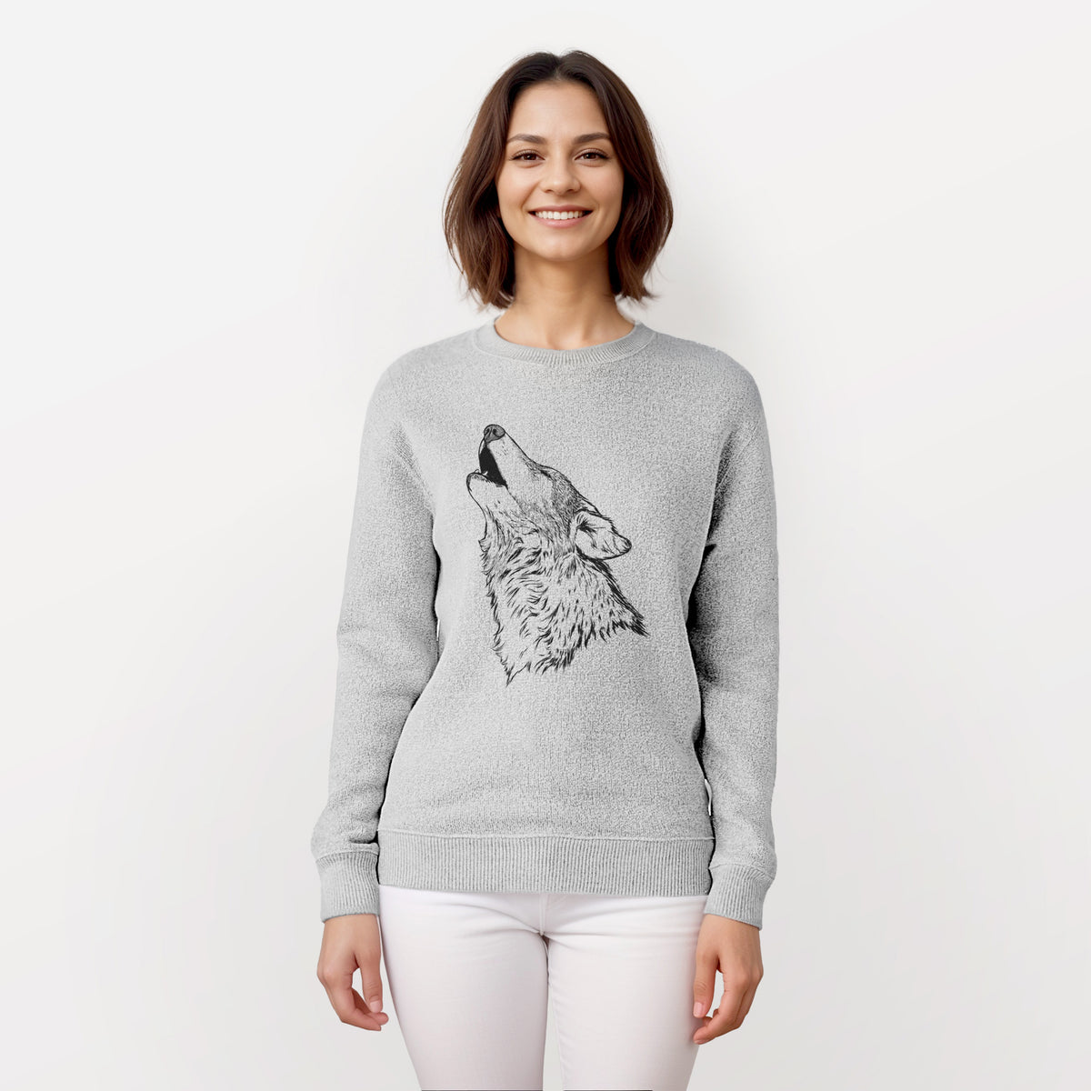 Woman wearing a knit sweatshirt printed with a detailed black ink illustration of a grey wolf's head and shoulders, howling upward.