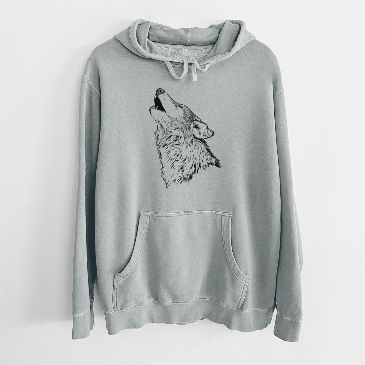 Sage green pigment dyed hoodie laid flat, printed with a detailed black ink illustration of a grey wolf's head and shoulders, howling upward.