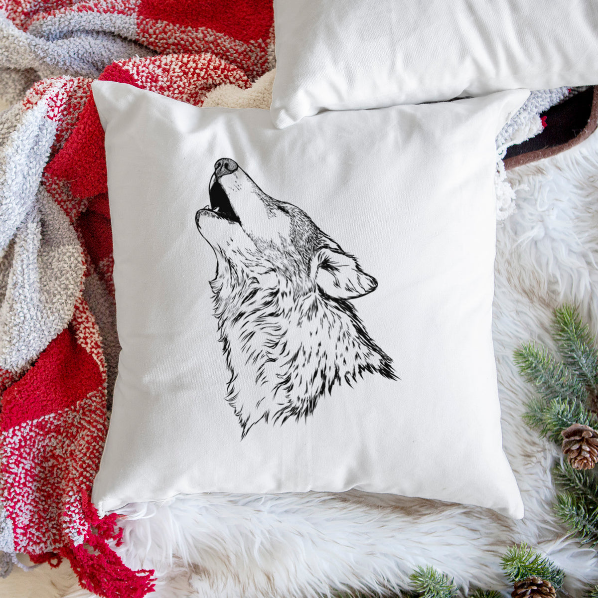 White pillow cover printed with a detailed black ink illustration of a grey wolf's head and shoulders, howling upward, on a woven chair.