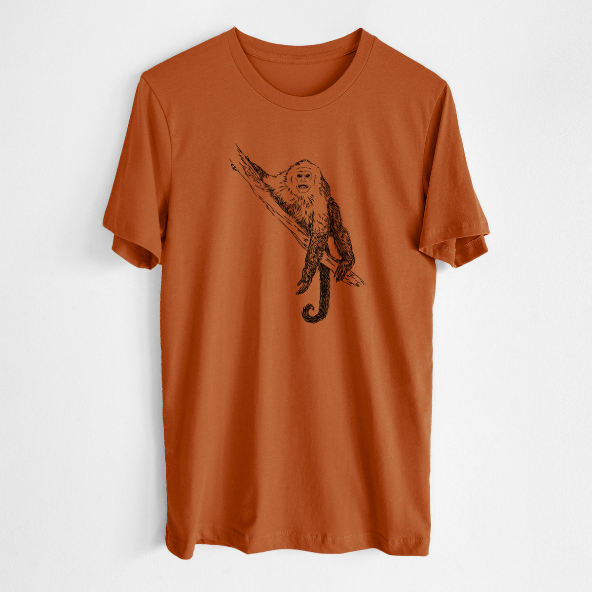 Autumn lightweight cotton t-shirt laid flat, printed with a detailed black ink illustration of a capuchin monkey climbing a branch.