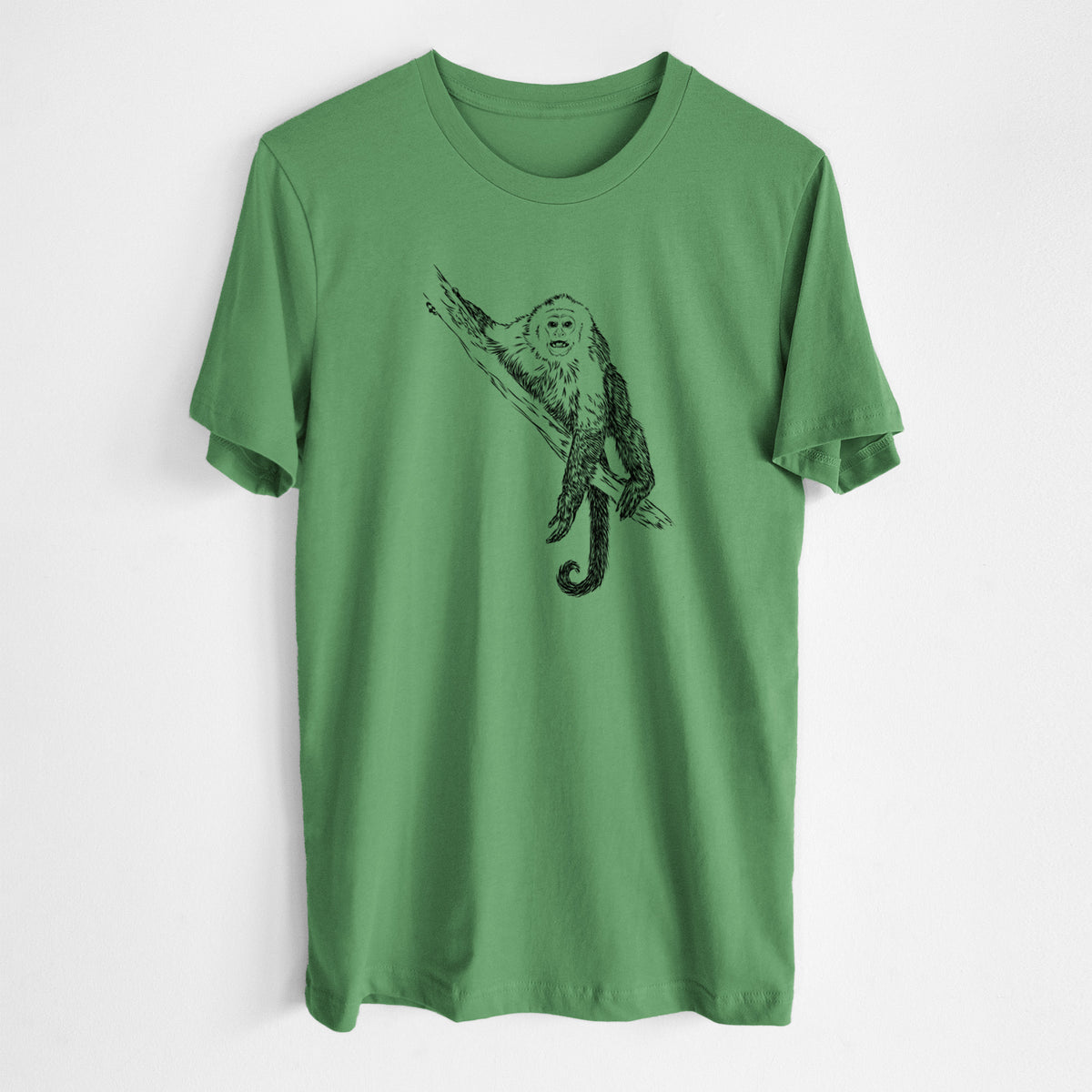 Leaf green lightweight cotton t-shirt laid flat, printed with a detailed black ink illustration of a capuchin monkey climbing a branch.