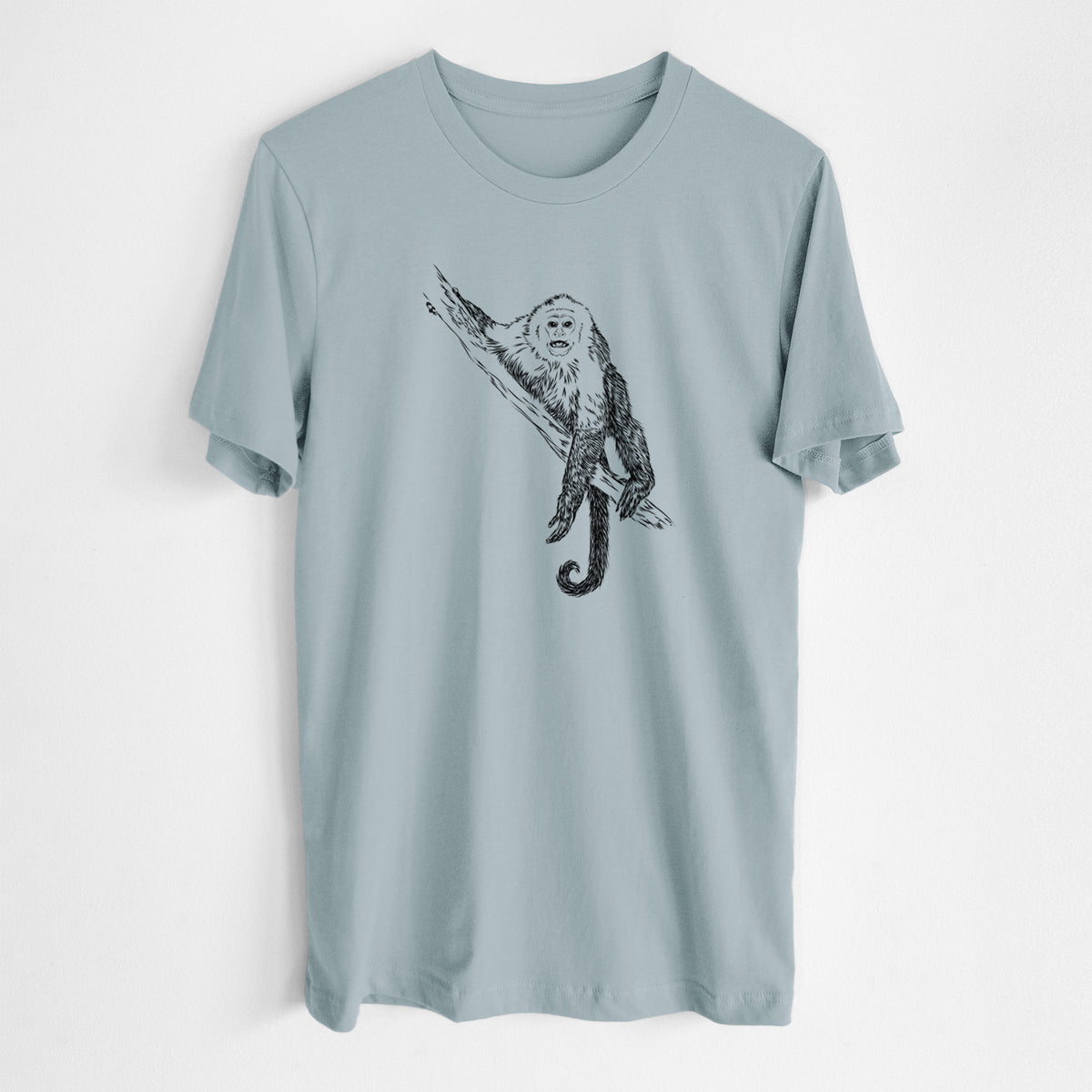 Vintage denim lightweight cotton t-shirt laid flat, printed with a detailed black ink illustration of a capuchin monkey climbing a branch.