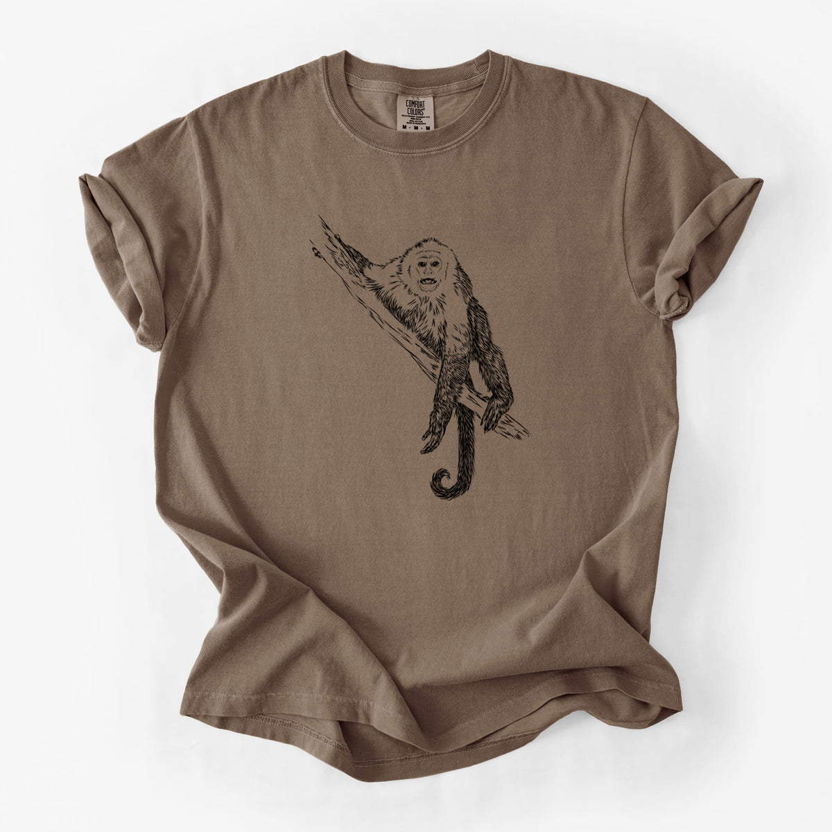Espresso brown Comfort Colors t-shirt laid flat, printed with a detailed black ink illustration of a capuchin monkey climbing a branch.