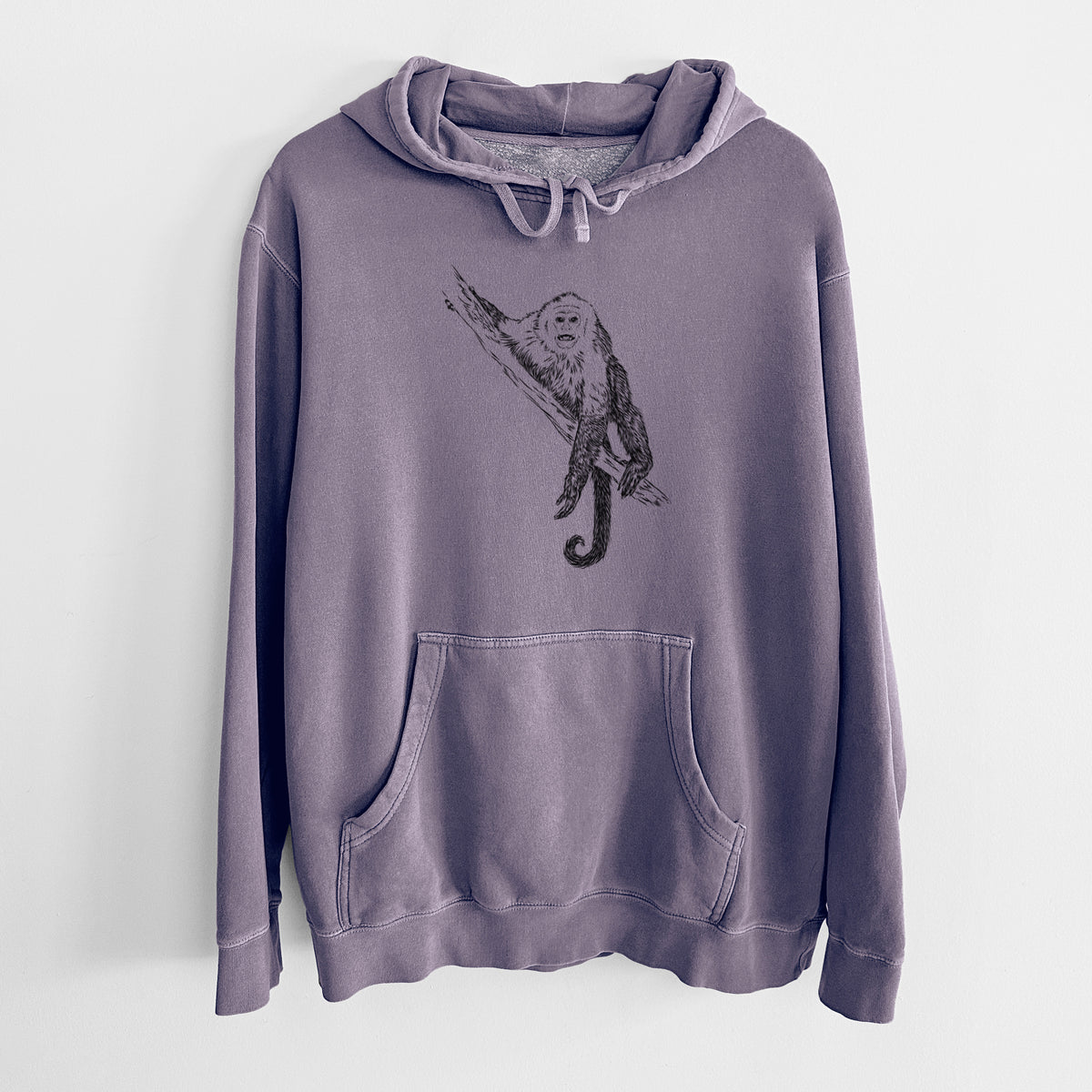 Plum purple pigment dyed hoodie laid flat, printed with a detailed black ink illustration of a capuchin monkey climbing a branch.