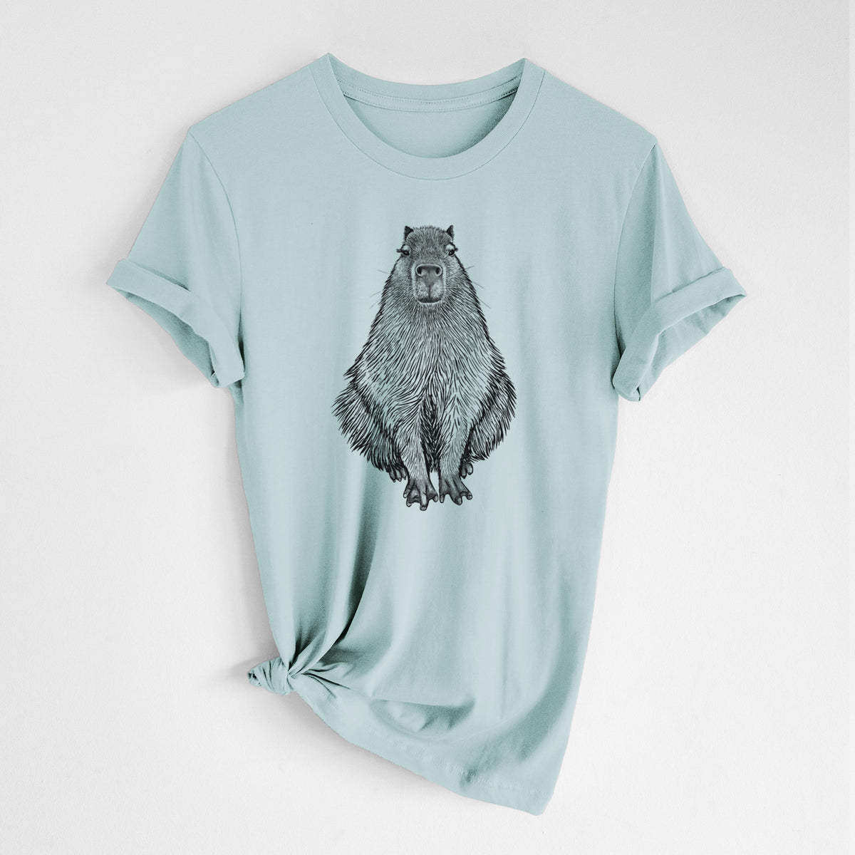 Dusty blue lightweight cotton t-shirt laid flat with the sleeves rolled, printed with a detailed black ink illustration of a capybara sitting and facing forward.