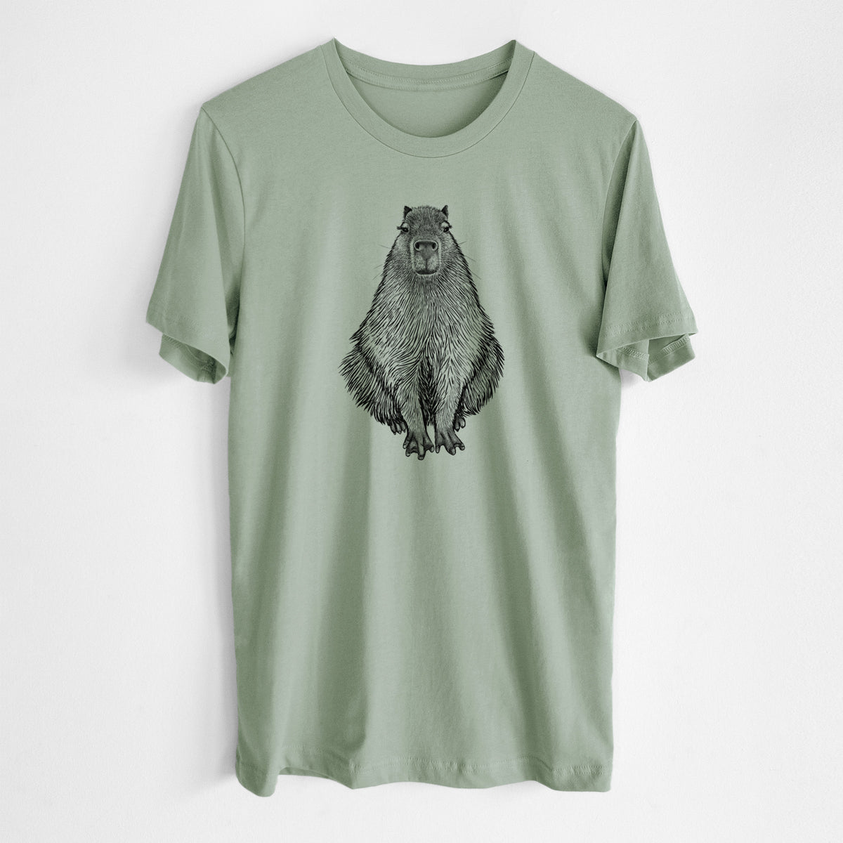 Sage green lightweight cotton t-shirt laid flat, printed with a detailed black ink illustration of a capybara sitting and facing forward.