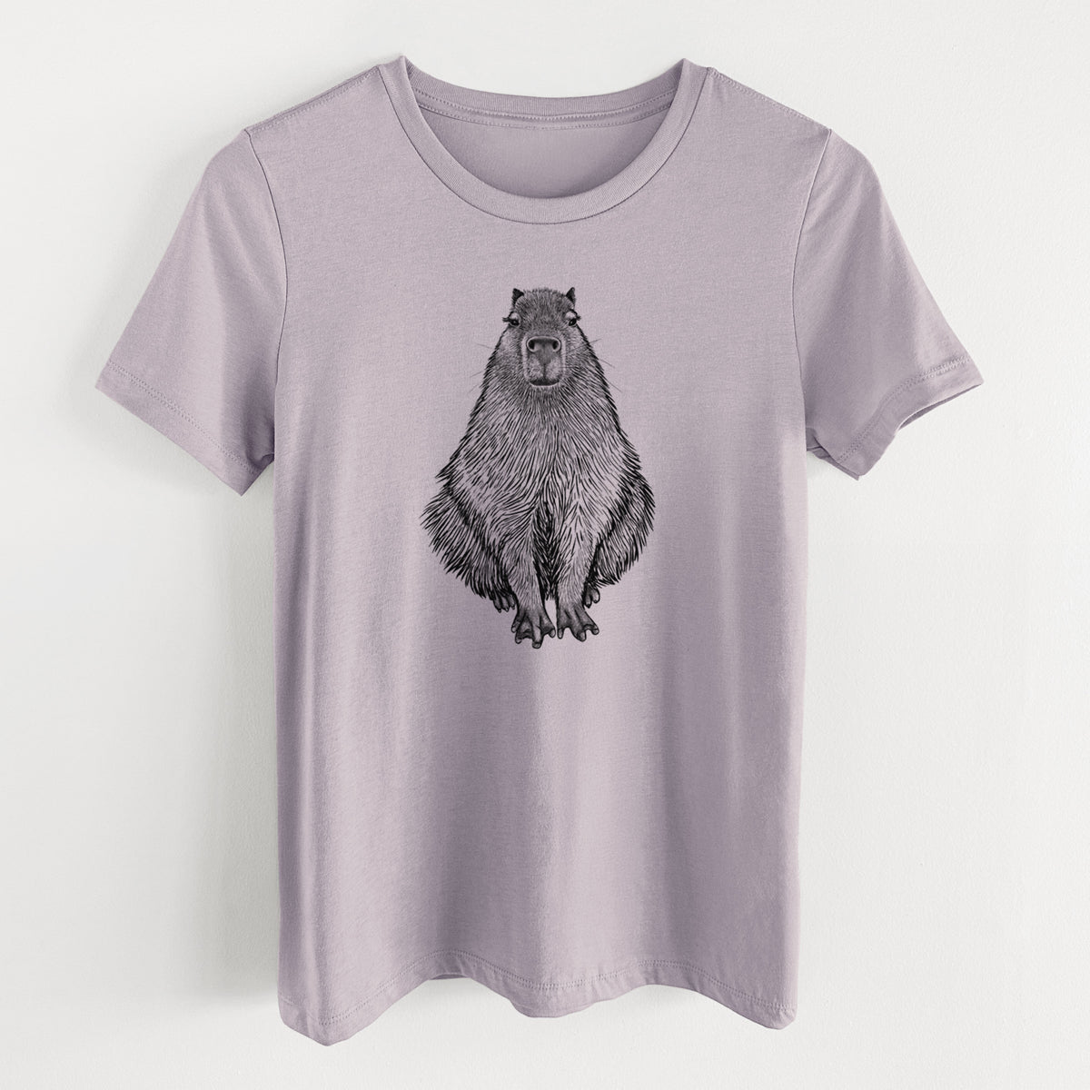 Light violet women's relaxed fit cotton t-shirt laid flat, printed with a detailed black ink illustration of a capybara sitting and facing forward.