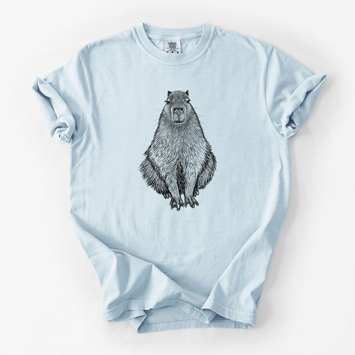 Chambray blue Comfort Colors t-shirt laid flat, printed with a detailed black ink illustration of a capybara sitting and facing forward.
