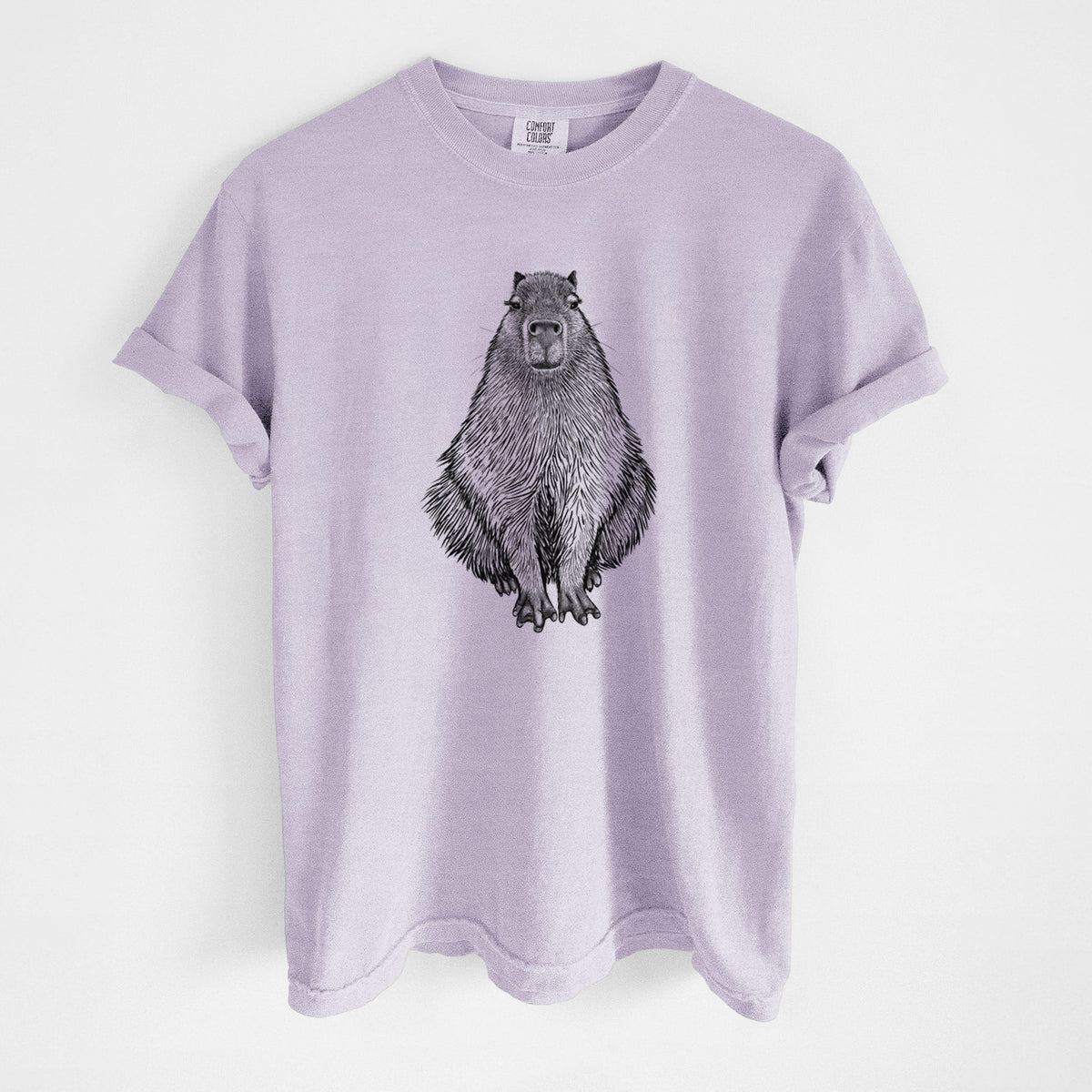 Orchid purple Comfort Colors t-shirt laid flat, printed with a detailed black ink illustration of a capybara sitting and facing forward.